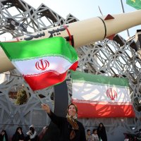 An Iranian woman waves a national flag next to a mock Iranian Kheibarshekan ballistic missile during a rally to show their support and solidarity with Supreme Leader Ayatollah Mojtaba Khamenei, in Tehran, Iran, June 4, 2026. (EPA Photo)