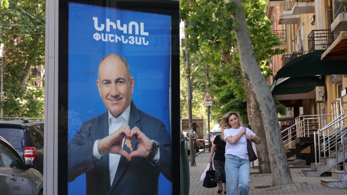 People walk past campaign banners with portraits of Prime Minister Nikol Pashinyan of the Civil Contract party, ahead of elections, Yerevan, Armenia, June 3, 2026. (Reuters Photo)