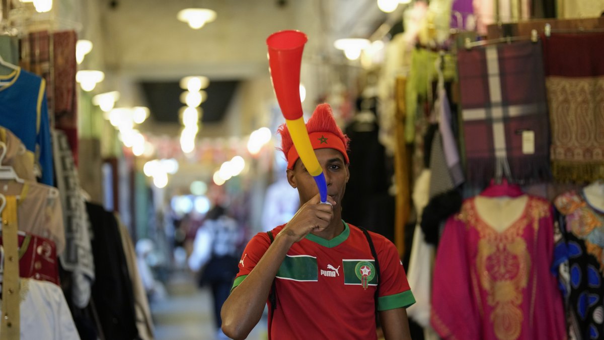 A fan of Morocco blows a vuvuzela in Souq Waqif market before a World Cup semifinal football match between France and Morocco, Doha, Qatar, Dec. 14, 2022. (AP Photo)
