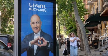 People walk past campaign banners with portraits of Prime Minister Nikol Pashinyan of the Civil Contract party, ahead of elections, Yerevan, Armenia, June 3, 2026. (Reuters Photo)