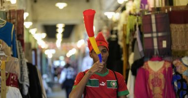 A fan of Morocco blows a vuvuzela in Souq Waqif market before a World Cup semifinal football match between France and Morocco, Doha, Qatar, Dec. 14, 2022. (AP Photo)