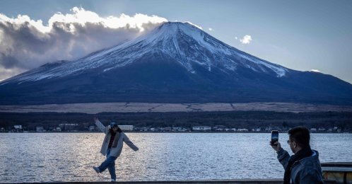People take photographs with Mount Fuji at Lake Yamanakako, Yamanashi Prefecture, Japan, Dec. 5, 2025. (AFP Photo)