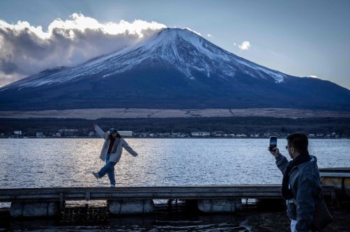 People take photographs with Mount Fuji at Lake Yamanakako, Yamanashi Prefecture, Japan, Dec. 5, 2025. (AFP Photo)