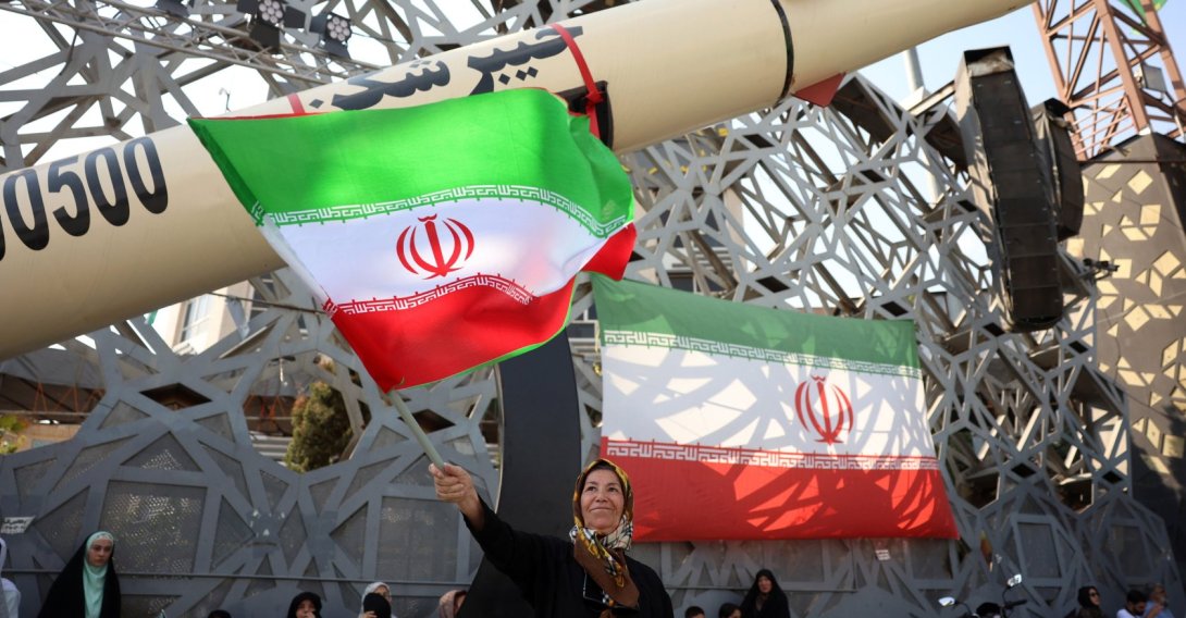 An Iranian woman waves a national flag next to a mock Iranian Kheibarshekan ballistic missile during a rally to show their support and solidarity with Supreme Leader Ayatollah Mojtaba Khamenei, in Tehran, Iran, June 4, 2026. (EPA Photo)