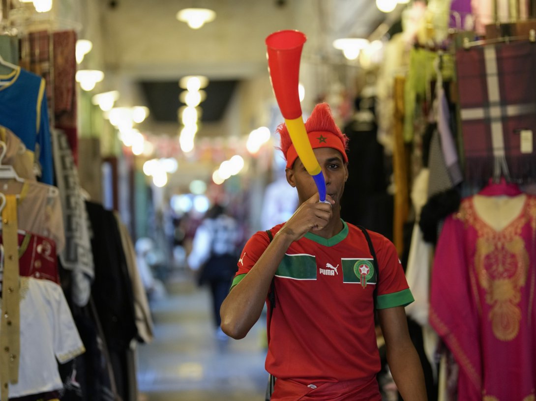 A fan of Morocco blows a vuvuzela in Souq Waqif market before a World Cup semifinal football match between France and Morocco, Doha, Qatar, Dec. 14, 2022. (AP Photo)