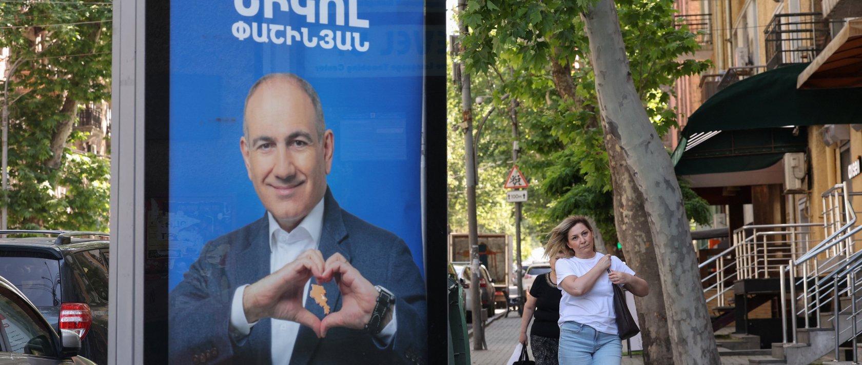 People walk past campaign banners with portraits of Prime Minister Nikol Pashinyan of the Civil Contract party, ahead of elections, Yerevan, Armenia, June 3, 2026. (Reuters Photo)