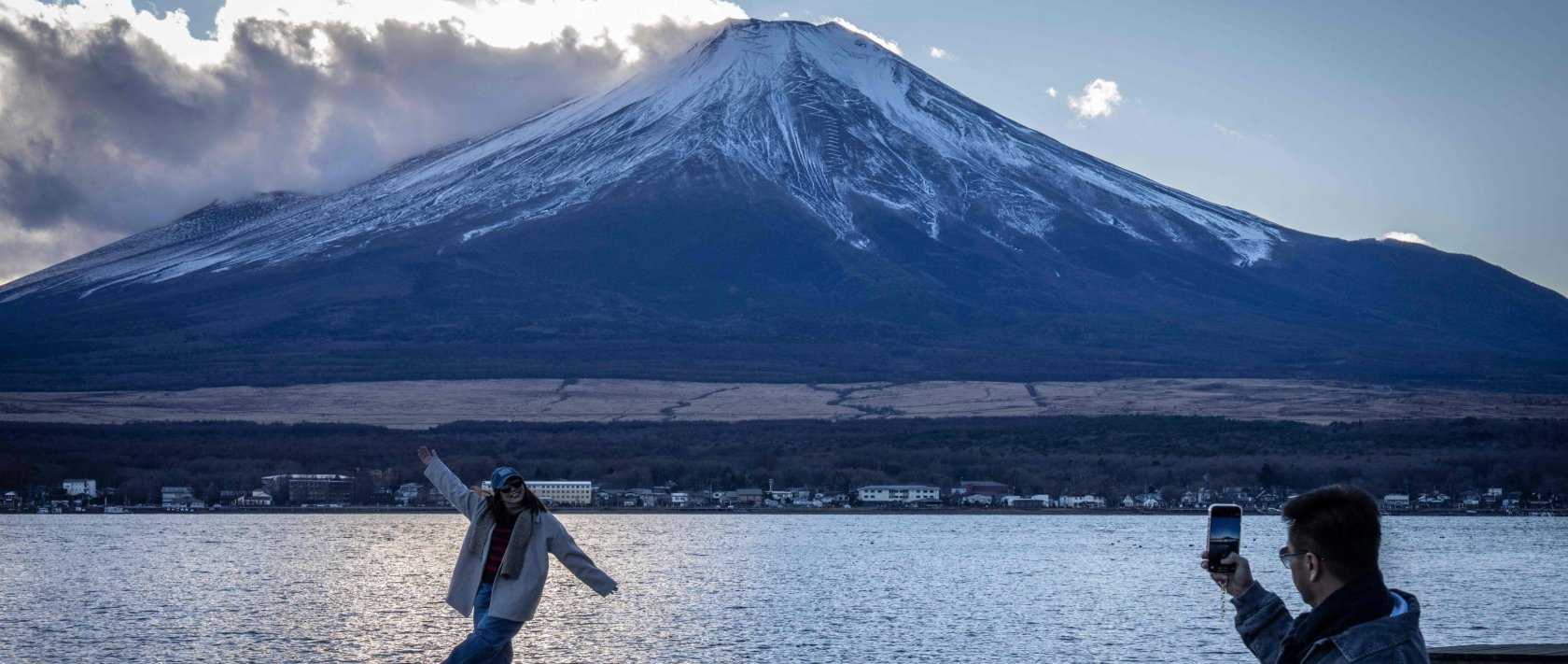 People take photographs with Mount Fuji at Lake Yamanakako, Yamanashi Prefecture, Japan, Dec. 5, 2025. (AFP Photo)