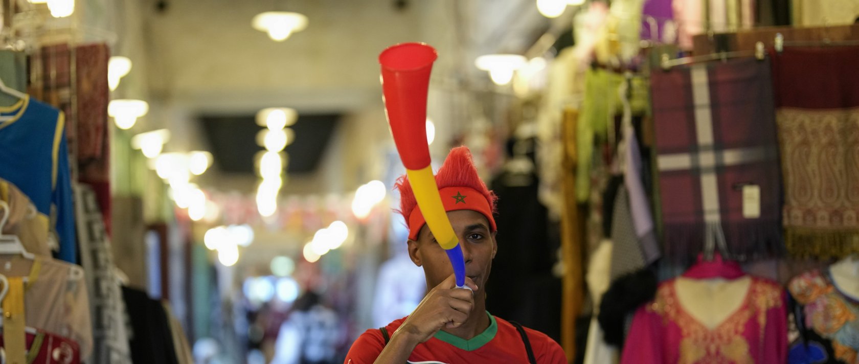 A fan of Morocco blows a vuvuzela in Souq Waqif market before a World Cup semifinal football match between France and Morocco, Doha, Qatar, Dec. 14, 2022. (AP Photo)