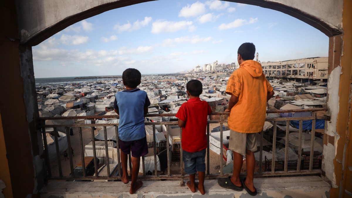 Three Palestinian children look down at tents housing displaced Palestinians in Gaza, Palestine, Sept. 3, 2025. (Getty Images Photo)