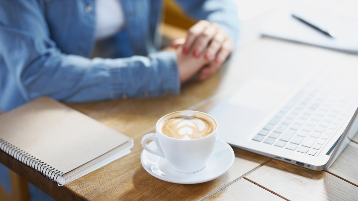 A woman works on a laptop at a cafe. (Shutterstock Photo) 