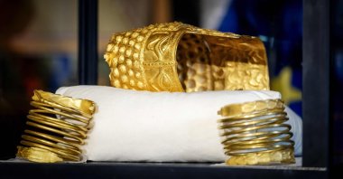 The recovered golden helmet of Cotofenesti and two gold bracelets that were stolen from the Drents Museum are displayed in a glass box, Assen, Netherlands, April 2, 2026. (AFP Photo)