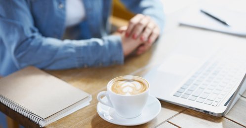 A woman works on a laptop at a cafe. (Shutterstock Photo) 