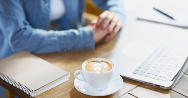 A woman works on a laptop at a cafe. (Shutterstock Photo) 