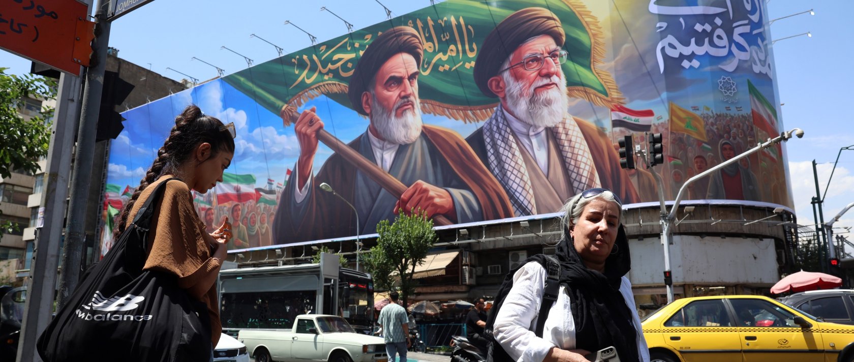 Iranians walk past a huge billboard featuring late Iranian Supreme Leader Ayatollah Ruhollah Khomeini and Supreme Leader Ayatollah Ali Khamenei, in Tehran, Iran, June 7, 2026. (EPA Photo)