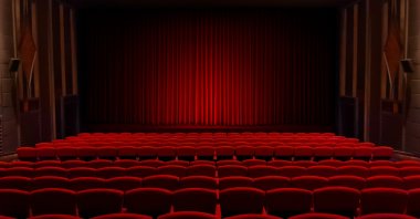 Empty theater seats facing red velvet stage curtain. (Shutterstock Photo)