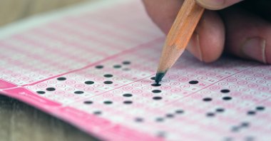 A student marks answers on a multiple-choice test sheet during an examination. (Shutterstock Photo) 