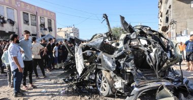 Palestinians look at the wreckage of a car hit by an Israeli airstrike in Gaza City, June 7, 2026. (AFP Photo)