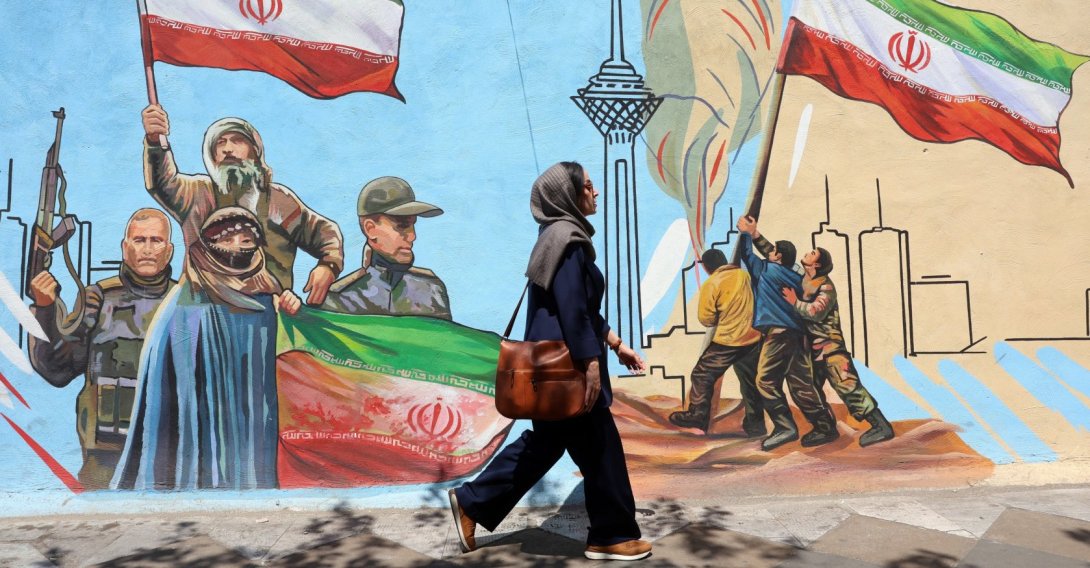 An Iranian woman walks past a mural on a street in Tehran, Iran, June 8, 2026. (EPA Photo)