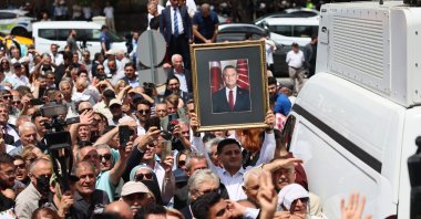 An attendee holds a portrait of Özgür Özel, ousted chair of the CHP, during a rally outside Parliament, Ankara, Türkiye, June 9, 2026. (AFP Photo)
