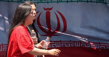 Women walk past Iran's national flag at Vanak Square in Tehran, Iran, June 10, 2026. (AFP Photo)