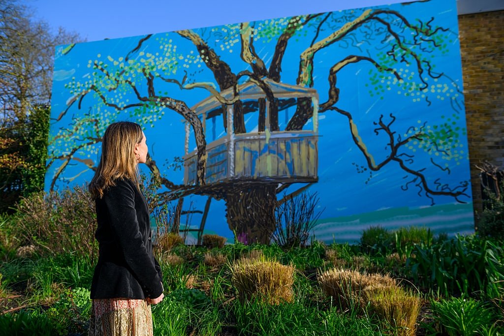 A visitor is seen looking at a large outdoor mural at the
