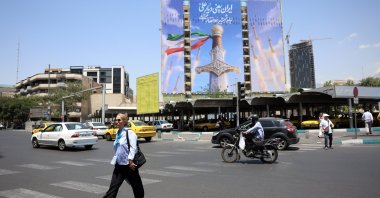 Iranians walk past a large-scale political billboard featuring Iranian missiles and a sword at Vanak Square in Tehran, Iran, June 11, 2026. (EPA Photo)