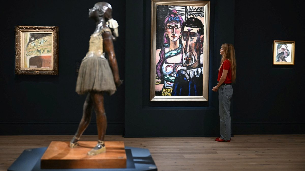 A staff member (R) poses next to Max Beckmann’s “Artisten” (back C), during a media preview by Sotheby's, London, U.K., June 11, 2026. (AFP Photo)