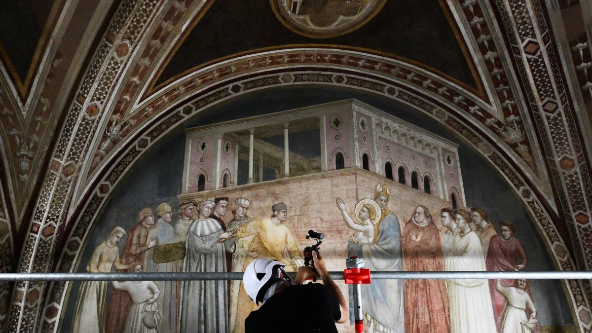 A cameraperson films during a press visit of the end of the restoration work of the 14th century frescoes of Giotto in the Basilica of Santa Croce, Florence, Italy, June 12, 2026. (AFP Photo)