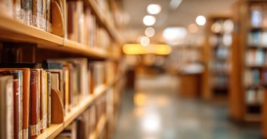 Rows of bookshelves filled with numerous books line a library aisle. (Shutterstock Photo)
