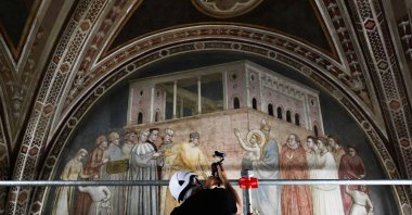 A cameraperson films during a press visit of the end of the restoration work of the 14th century frescoes of Giotto in the Basilica of Santa Croce, Florence, Italy, June 12, 2026. (AFP Photo)