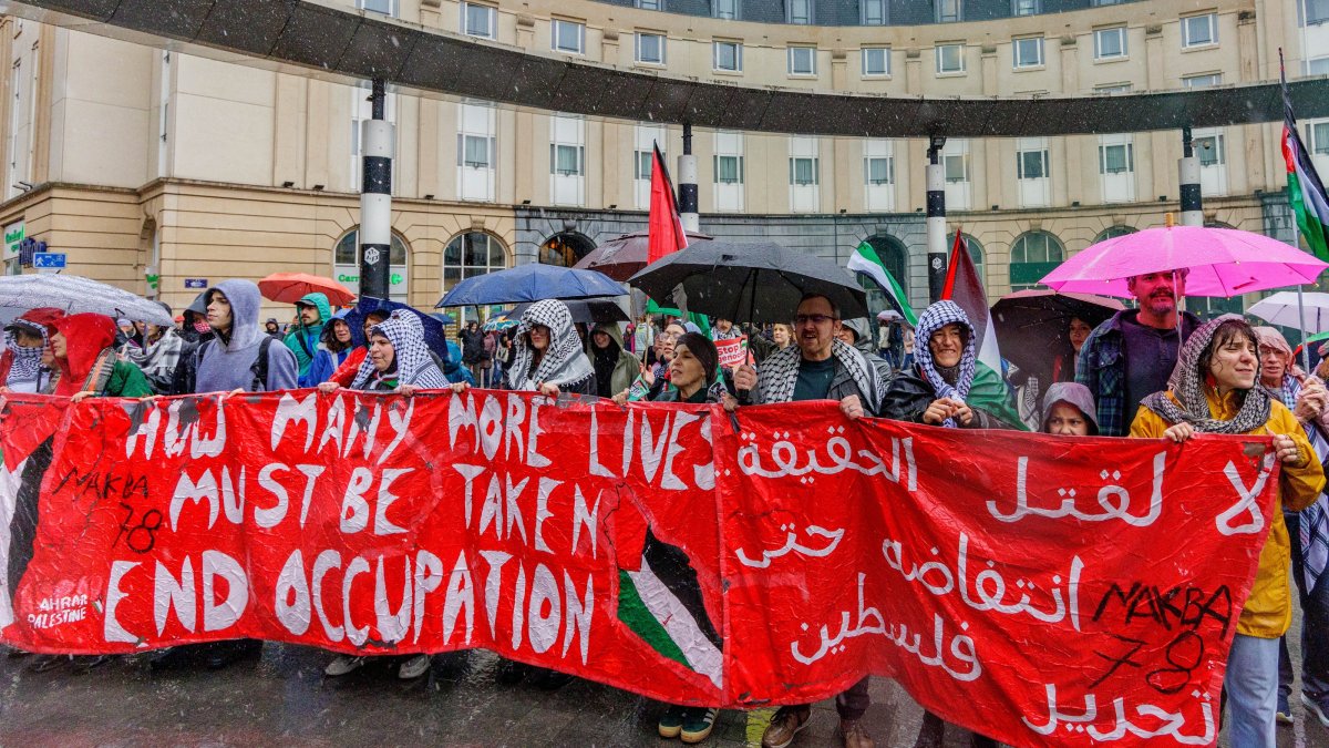 People carry a banner through the rain during a demonstration organized by the Belgian National Coalition for Palestine calling for the Palestinian people's right to self-determination and return, in Brussels, Belgium, May 17, 2026. (EPA File Photo)