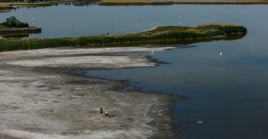 A drone view of people walking on the exposed lakebed of the drying Lake Velence, Velence, Hungary, June 9, 2026. (Reuters Photo)