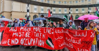 People carry a banner through the rain during a demonstration organized by the Belgian National Coalition for Palestine calling for the Palestinian people's right to self-determination and return, in Brussels, Belgium, May 17, 2026. (EPA File Photo)
