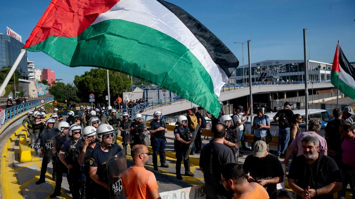 Greek security personnel stand alert in front of pro-Palestinian protestors as Israeli tourists arrive aboard Israeli-owned cruise ship MS Crown Iris at the port of Piraeus, Athens, Greece, June 3, 2026. (AFP Photo)