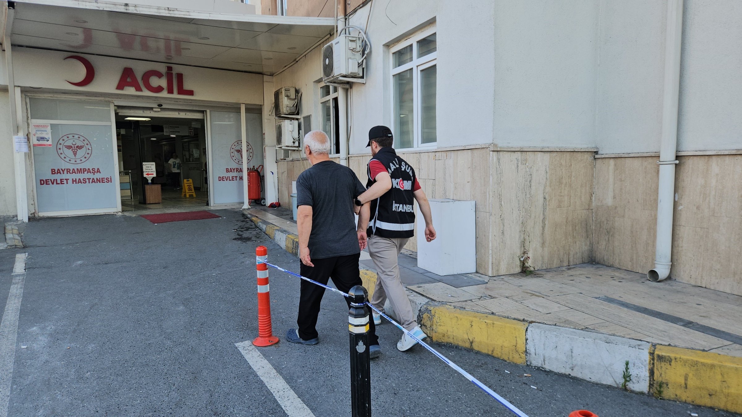A police officer escorts a suspect to a routine medical check before he is transferred to prison, Istanbul, Türkiye, June 16, 2026. (İHA Photo)