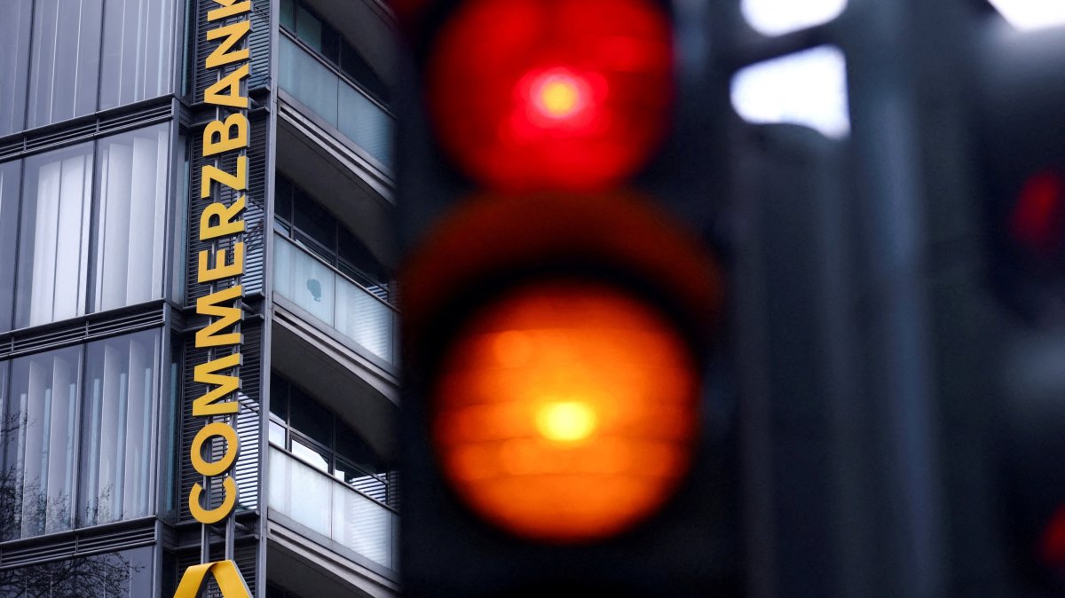 Traffic lights glow near a logo of Commerzbank at a branch, Cologne, Germany, March 16, 2026. (Reuters Photo)