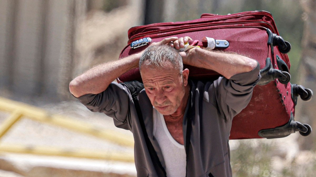 A man carries a suitcase as people retrieve their remaining belongings from the Nur Shams camp for Palestinian refugees, occupied West Bank, Palestine, June 16, 2026. (AFP Photo)
