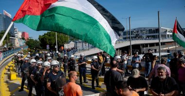 Greek security personnel stand alert in front of pro-Palestinian protestors as Israeli tourists arrive aboard Israeli-owned cruise ship MS Crown Iris at the port of Piraeus, Athens, Greece, June 3, 2026. (AFP Photo)