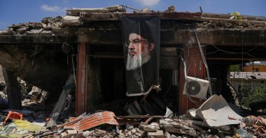 A banner with an image of late Hezbollah leader Hassan Nasrallah hangs from a destroyed building in Jibchit, Nabatieh district, Lebanon, June 16, 2026. (Reuters Photo)
