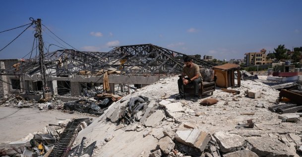 A man sits amid the rubble in Jibchit in the Nabatieh district, Lebanon, June 16, 2026. (Reuters Photo)