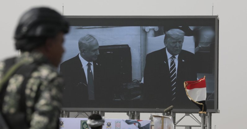 A Houthi soldier stands guard in front of a digital billboard featuring U.S. President Donald Trump and Israeli Prime Minister Benjamin Netanyahu, in Sana'a, Yemen, May 18, 2026. (EPA Photo)