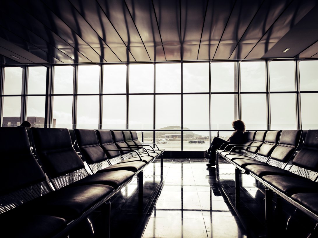 A person sits alone at the airport. (Shutterstock Photo)