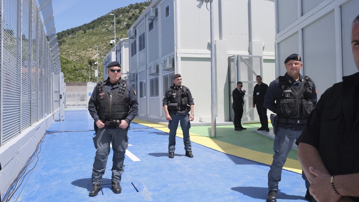 Policemen guard a reception center for migrants at the port of Shenjin, northwestern Albania, June 5, 2024. (AP Photo)