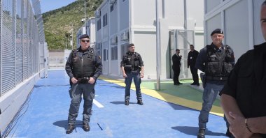 Policemen guard a reception center for migrants at the port of Shenjin, northwestern Albania, June 5, 2024. (AP Photo)