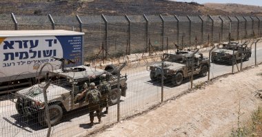 Israel military vehicles drive along the border fence into Israel, near the town of Majdal Shams, in the Israeli-annexed Golan Heights, July 17, 2025. (AFP File Photo)