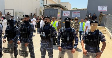 Security personnel stand guard as protesters gather outside the headquarters of the UNHCR, in Tripoli, Libya, June 4, 2026. (Reuters Photo)