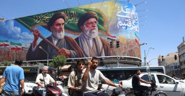 An Iranian shows a victory sign as he drives past a billboard of the late Iranian supreme leaders Ayatollah Ruhollah Khomeini and Ayatollah Ali Khamenei on a street in Tehran, Iran, June 15, 2026. (EPA Photo)