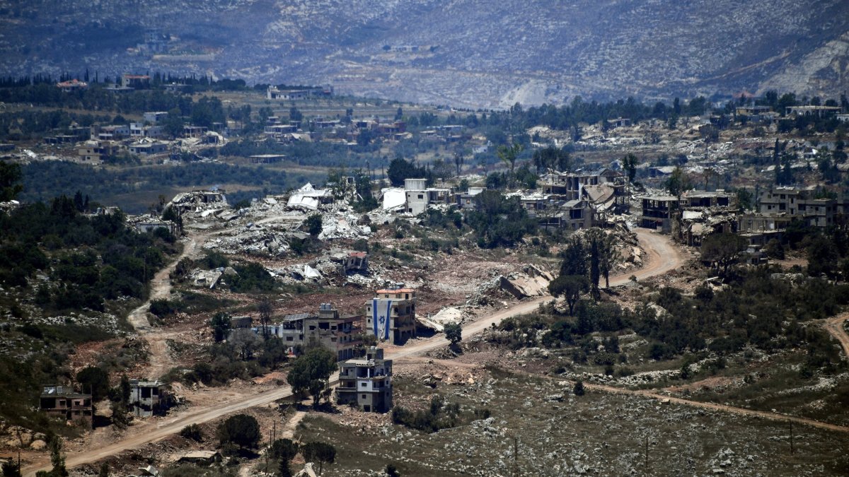 An Israeli flag hangs from a damaged building in a village inside south Lebanon close to the border as seen from northern Israel, June 18, 2026. (Reuters Photo)