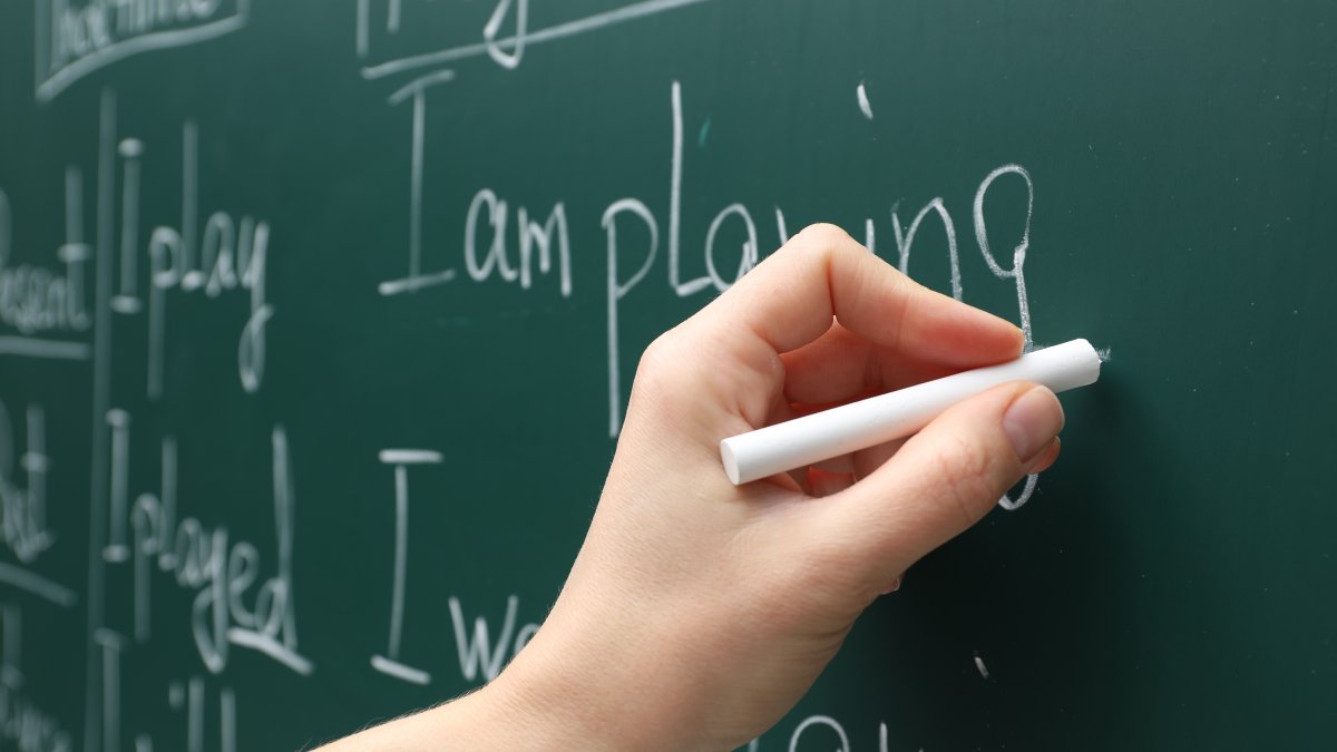 An English teacher writes on a board during a lesson at school. (Shuttterstock Photo) 