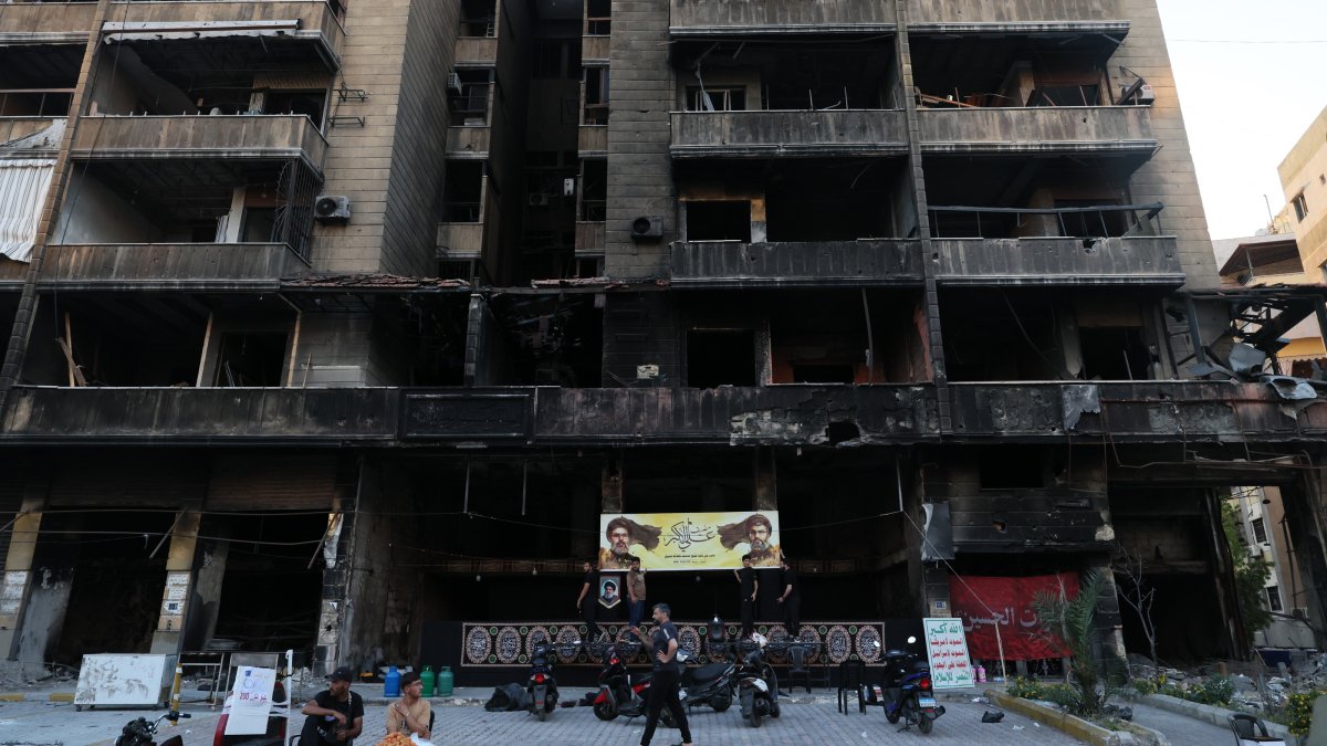 Supporters of Hezbollah hang a banner depicting portraits of late Hezbollah leaders Hassan Nasrallah and Hashem Safieddine in a partially damaged building targeted by an Israeli strike, in the southern suburbs of Beirut, Lebanon,  June 17, 2026. (EPA Photo)